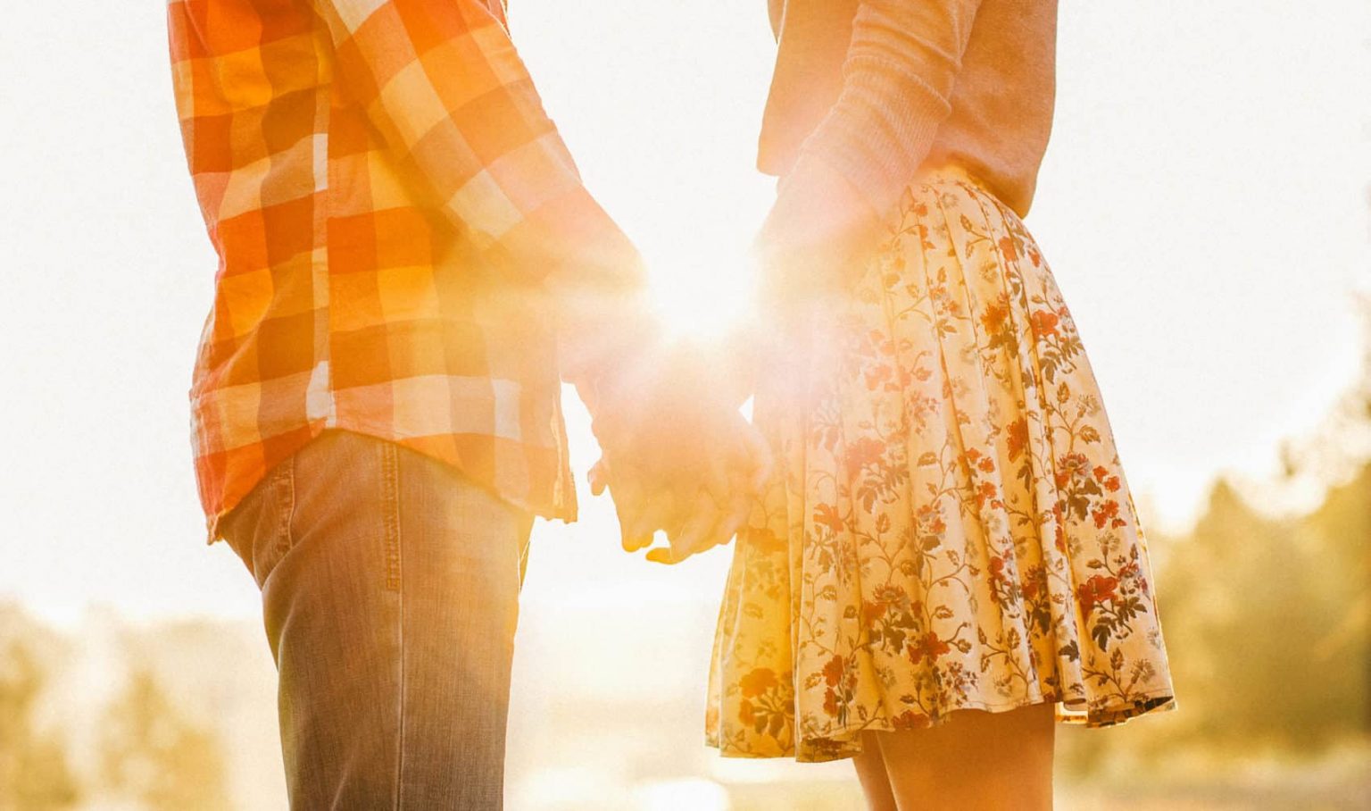 Young couple in love walking in the autumn park holding hands